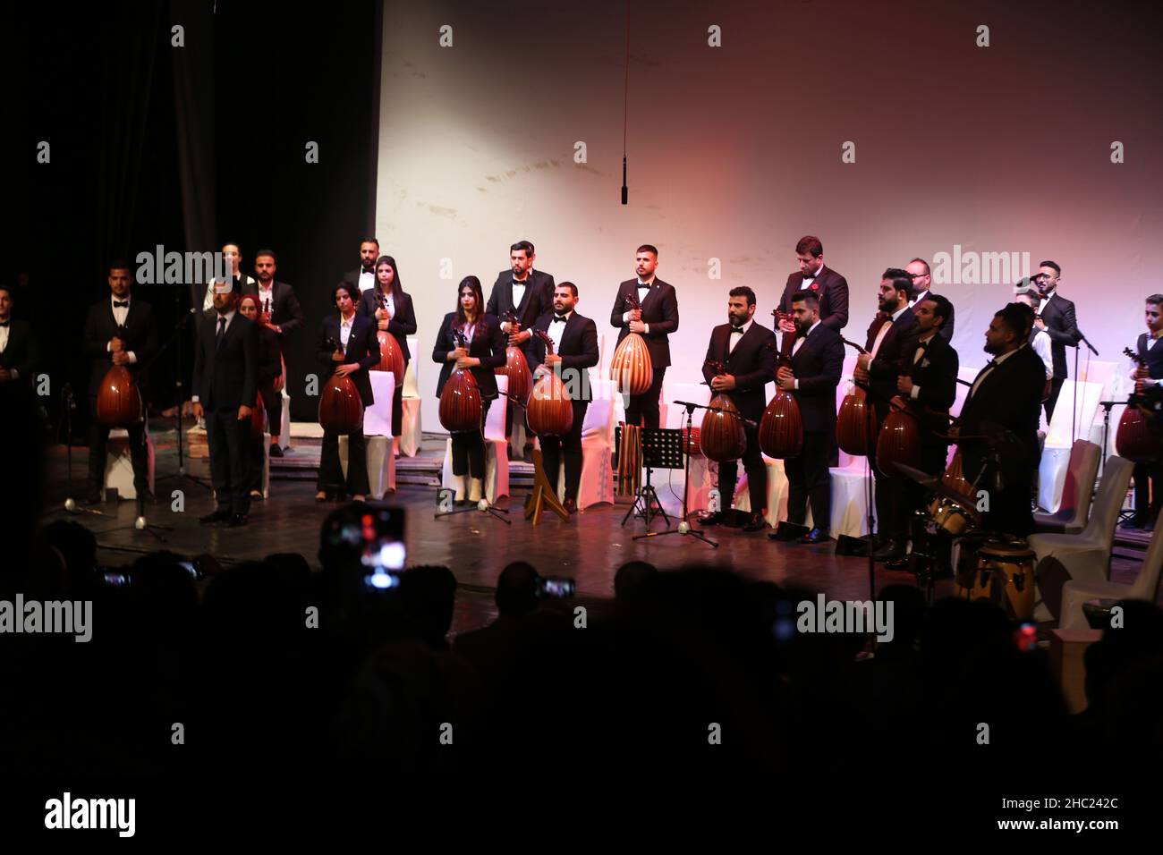 (211218) -- BAGHDAD, 18 dicembre 2021 (Xinhua) -- l'orchestra al-Oud (Lute) saluta il pubblico al Teatro al-Rasheed di Baghdad, Iraq, il 17 dicembre 2021. L'orchestra si è esibita al teatro, che ha aperto il mese scorso dopo essere stata chiusa per più di 18 anni. (Xinhua/Khalil Dawood) Foto Stock
