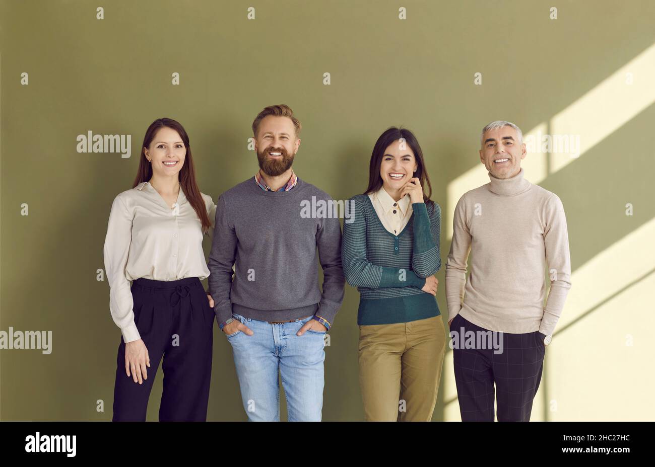 Ritratto di gruppo di quattro uomini d'affari felici in abiti casual elegante in piedi in studio Foto Stock