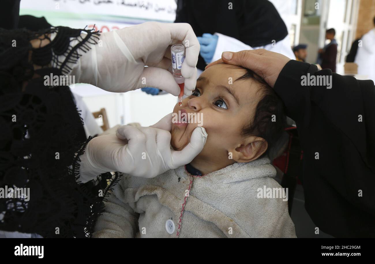(211219) -- SANAA, 19 dicembre 2021 (Xinhua) -- un operatore sanitario dà un vaccino antipolio ad un bambino durante una campagna di vaccinazione di emergenza a Sanaa, Yemen, 18 dicembre 2021. In collaborazione con l'Organizzazione Mondiale della Sanità, le autorità sanitarie delle province settentrionali dello Yemen hanno lanciato sabato una campagna di vaccinazione contro il morbillo, la polio e la rosolia per bambini. (Foto di Mohammed Mohammed/Xinhua) Foto Stock