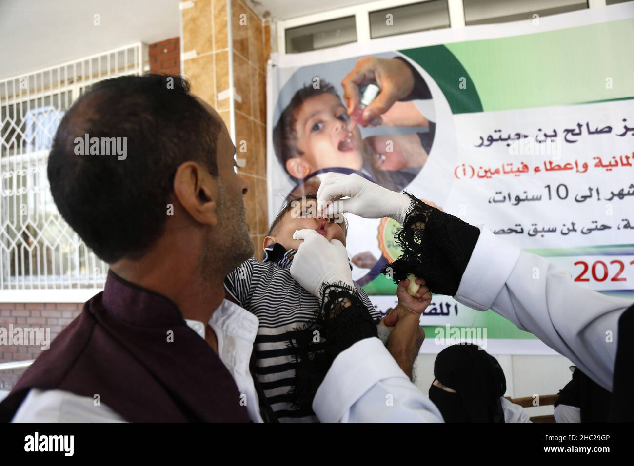 (211219) -- SANAA, 19 dicembre 2021 (Xinhua) -- un operatore sanitario dà un vaccino antipolio ad un bambino durante una campagna di vaccinazione di emergenza a Sanaa, Yemen, 18 dicembre 2021. In collaborazione con l'Organizzazione Mondiale della Sanità, le autorità sanitarie delle province settentrionali dello Yemen hanno lanciato sabato una campagna di vaccinazione contro il morbillo, la polio e la rosolia per bambini. (Foto di Mohammed Mohammed/Xinhua) Foto Stock