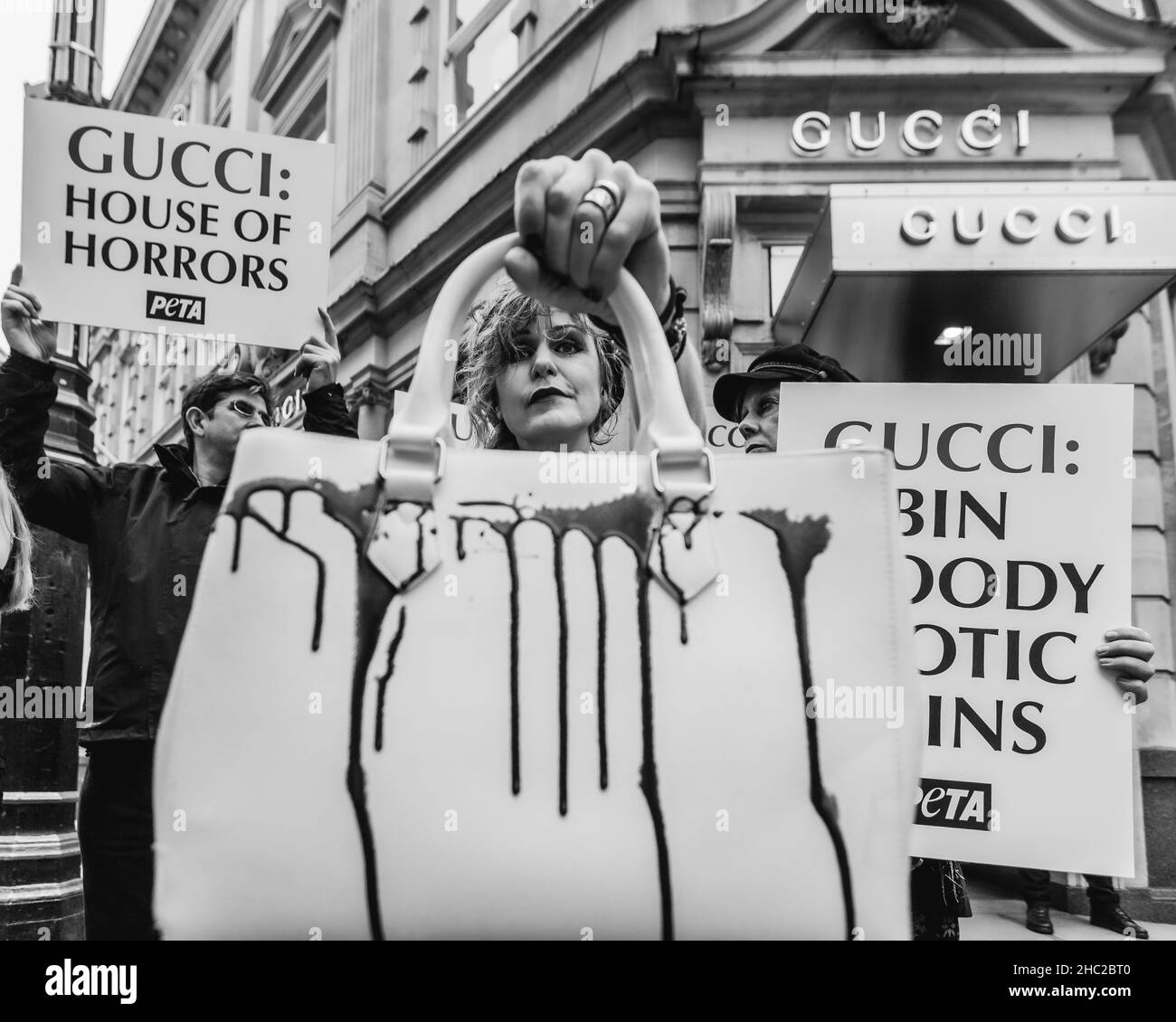 House of Horrors: Immagine in bianco e nero di pelli esotiche PETA protesta fuori Gucci Store a Londra con le borse coperte di sangue falso. Foto Stock