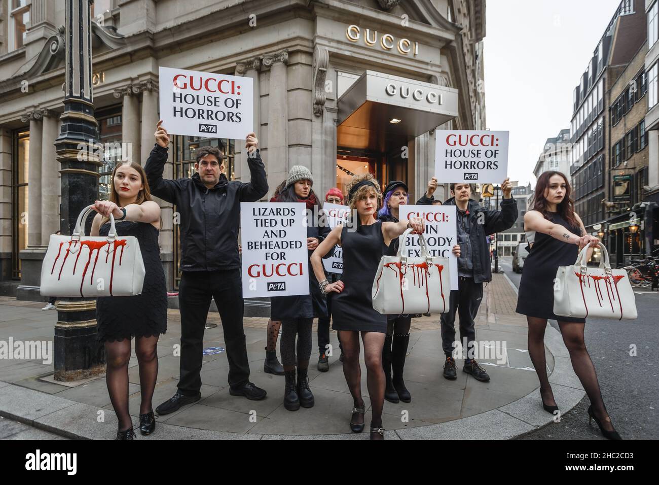 PETA tiene in mano i cartelli della House of Horrors per protestare contro l'uso della pelle di lucertola per le loro borse fuori dal Gucci Store di Londra. Foto Stock