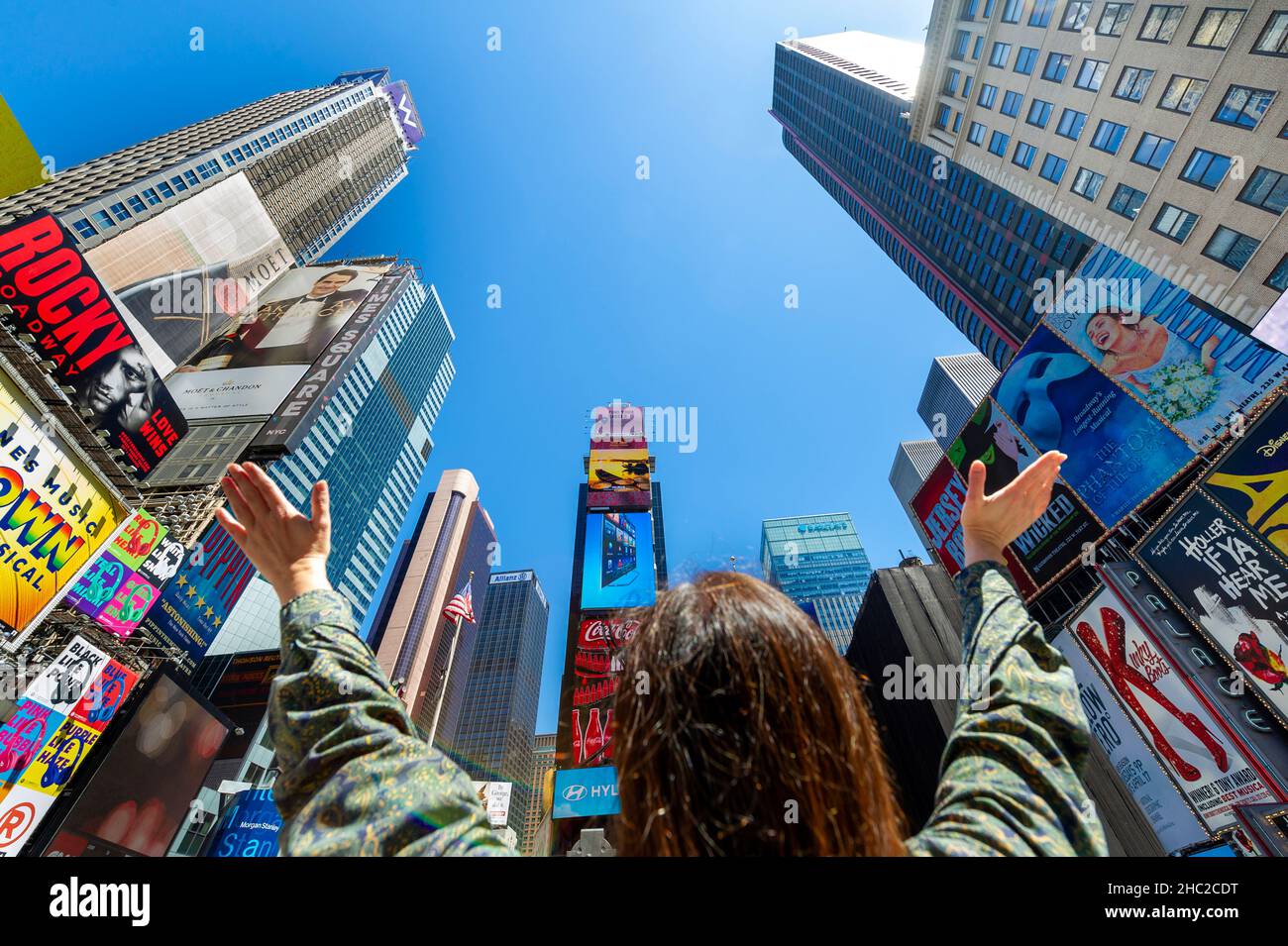 Donna con le mani in su nell'eccitamento al Times Square, New York Foto Stock