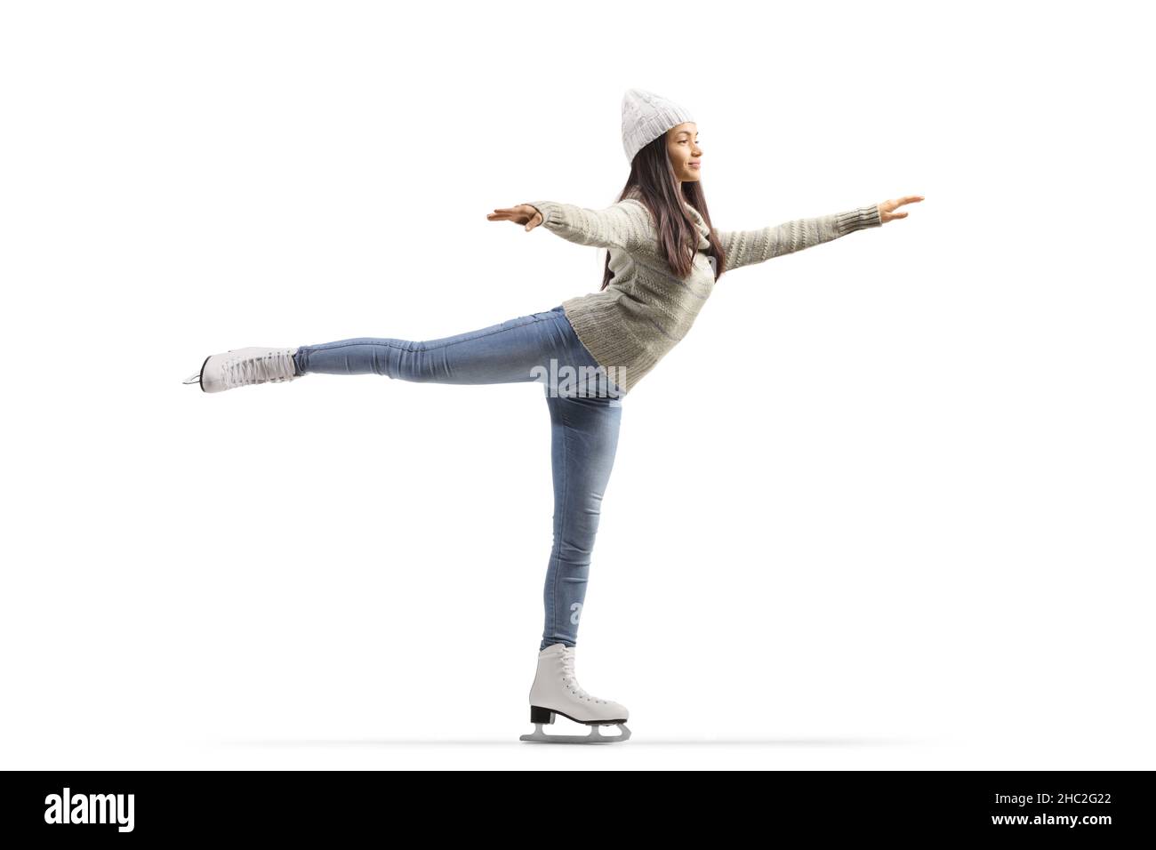 Scatto completo di una giovane donna casual pattinaggio su ghiaccio con una gamba isolata su sfondo bianco Foto Stock