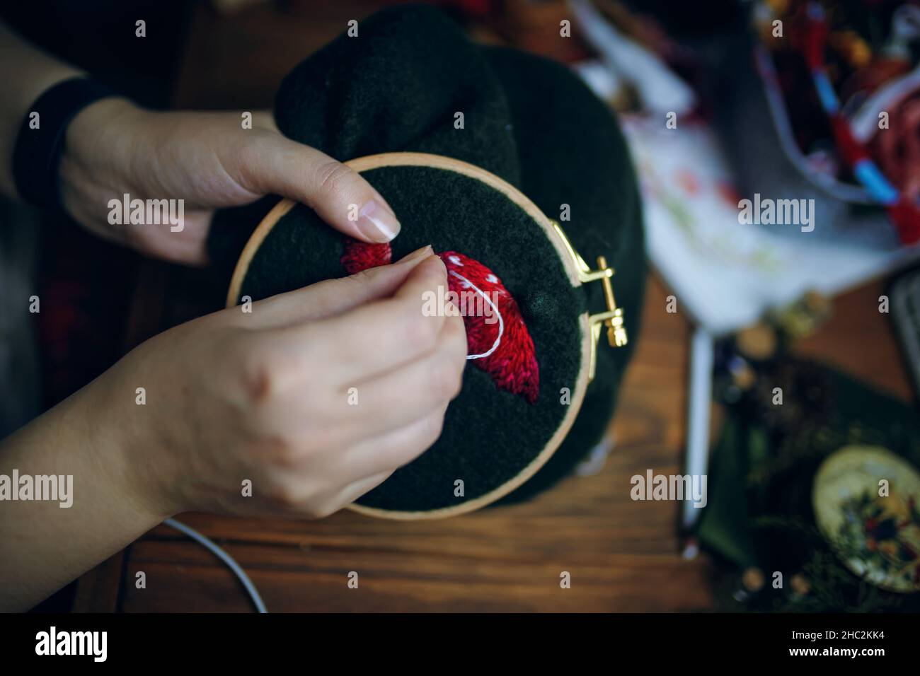 I ricami da donna volano il cappello agarico sul telaio. Foto Stock