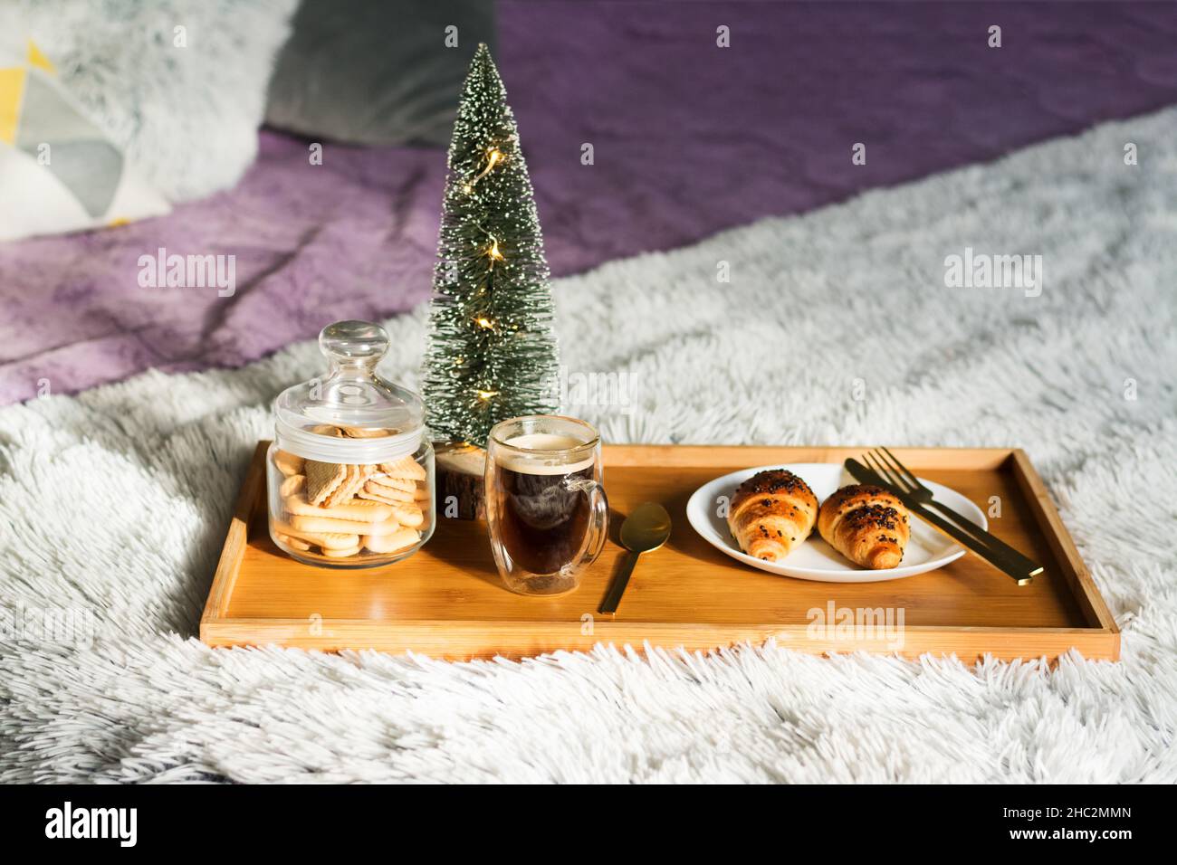 Colazione in camera con tazza di caffè, croissant e biscotti sul vassoio di Natale mattina Foto Stock