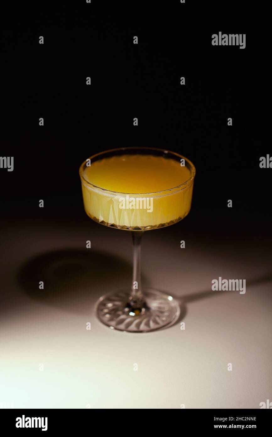 Bicchiere di cocktail mimosa senza alcol alla frutta vegana. Sfondo scuro Foto Stock
