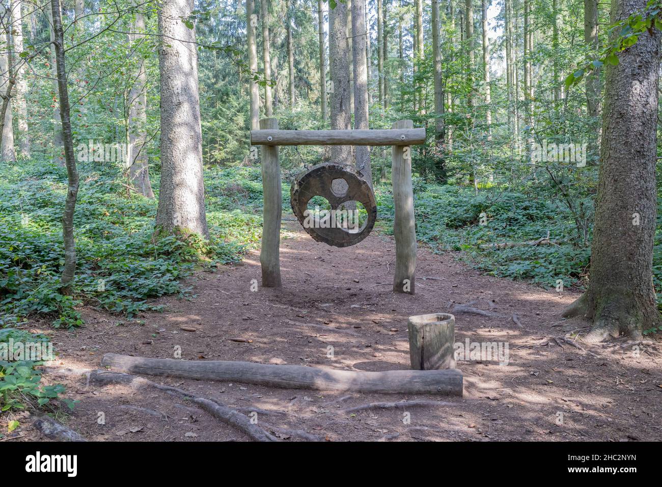 Gioco di mira, pannello di un tronco di albero con buchi per lanciare palle, vegetazione selvaggia e alberi sullo sfondo, area ricreativa per i bambini in un'escursione Foto Stock