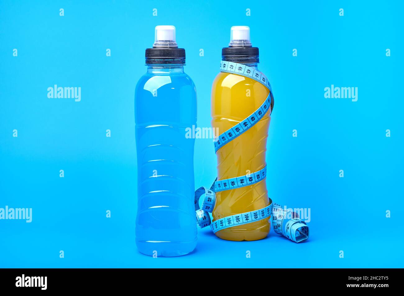 Energia isotonica giallo arancio e blu bevanda sportiva in bottiglie di  plastica su sfondo giallo. Consente di mantenere il più ottimale equilibrio  di acqua, sale ed elettroliti durante il gioco sportivo Foto