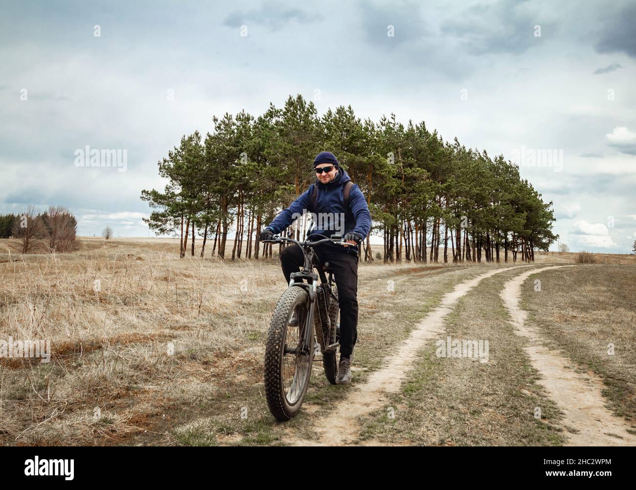 Un uomo guida una bici elettrica con ruote spesse. Hobby sportivo. Foto Stock