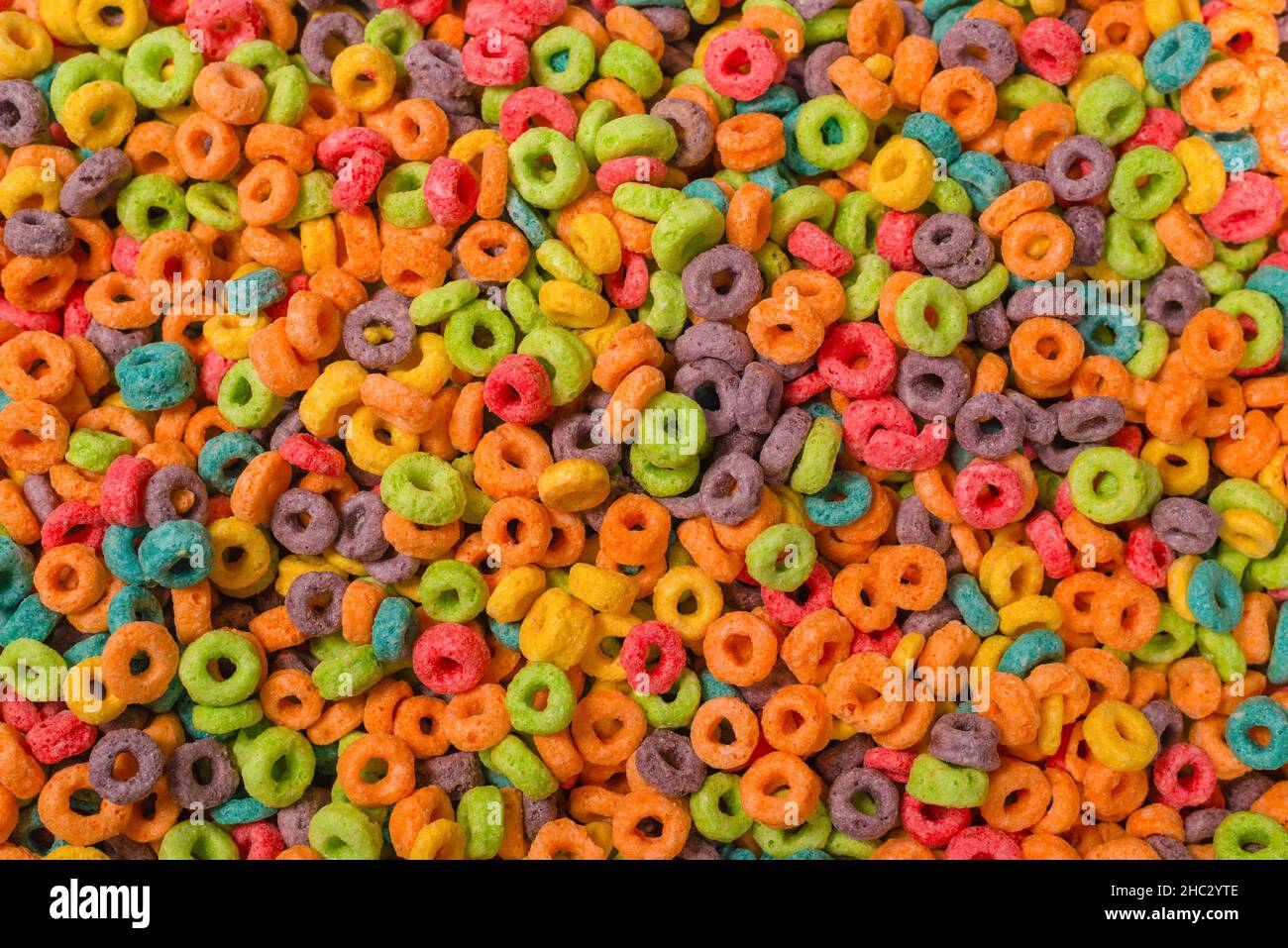 Dolci fiocchi multicolore, anelli di cereali come sfondo. Foto Stock