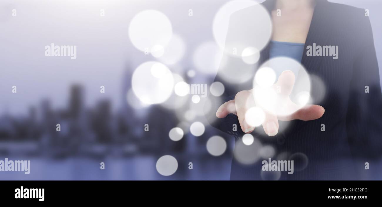 Concetto di tecnologia di innovazione e comunicazione delle reti aziendali. Mano touch schermo digitale ologramma cerchi segno sulla città luce sfondo sfocato. Poll Foto Stock