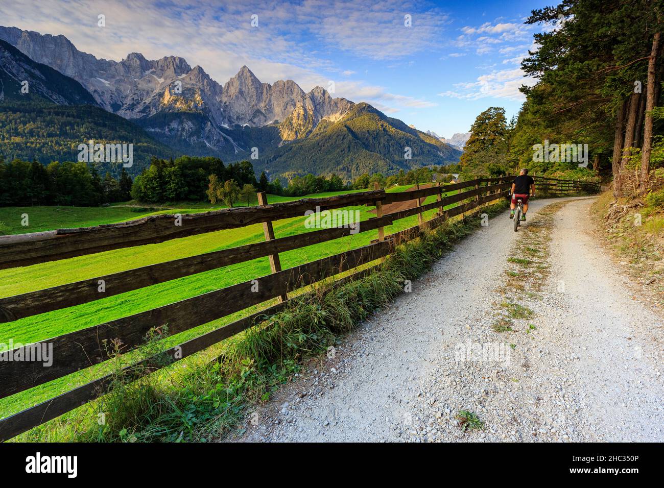 Gli appassionati di mountain bike si godono l'alba al Triglav Nationalpark, scenario di montagna con una vetta incandescente spik, vicino a Kranjska Gora, Slovenia Foto Stock