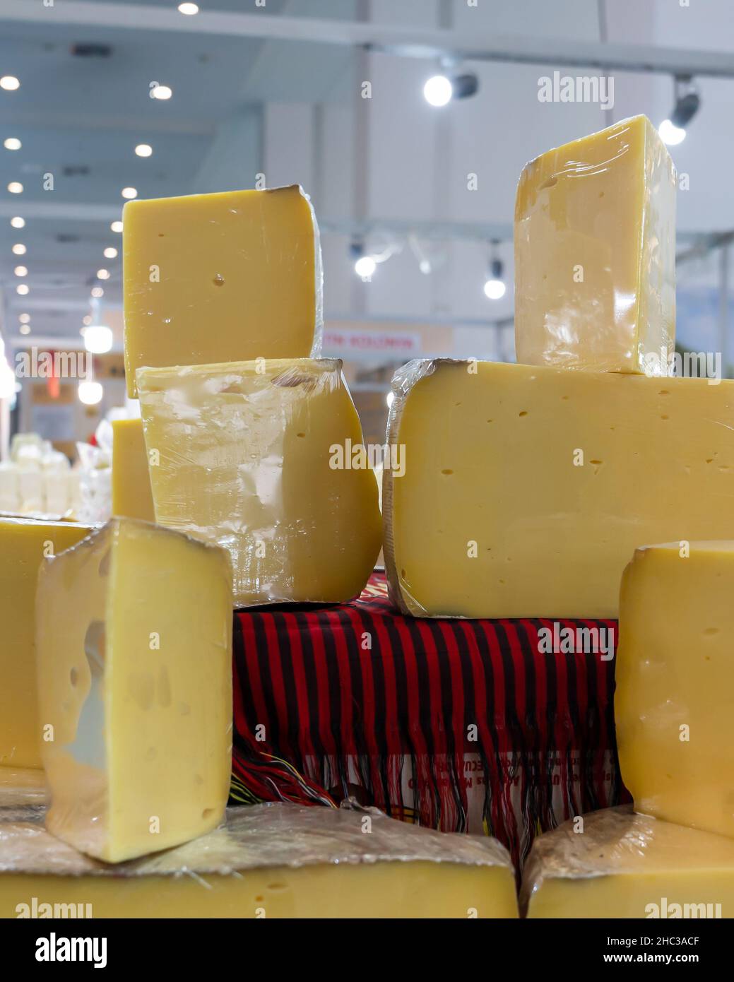 Cheddar, formaggio kashar avvolto con nastro estensibile è venduto in un mercato in condizioni igieniche. Foto Stock