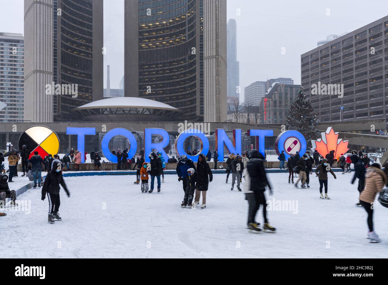 Toronto, Ontario, Canada - Dicembre 18 2021 : persone che pattinano su ghiaccio a Nathan Phillips Square nel giorno d'inverno durante il periodo pandemico di covid-19. Foto Stock