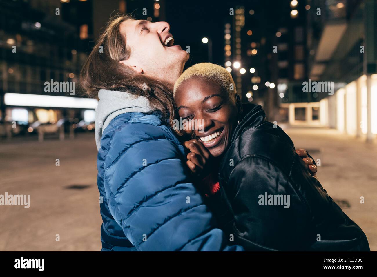 Italia, felice coppia che abbraccia in città di notte Foto Stock
