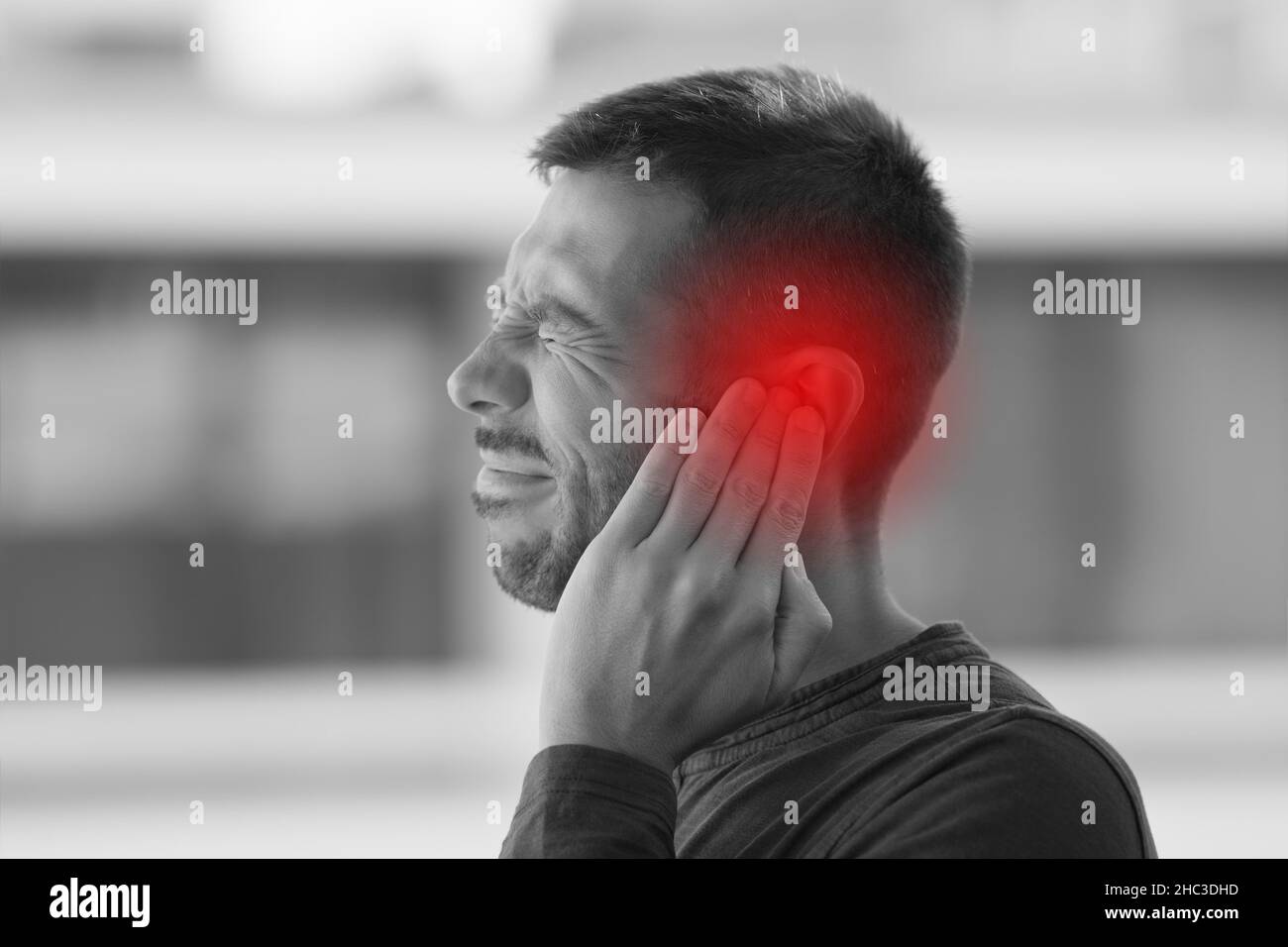 Giovane che soffre di forte dolore all'orecchio o all'orecchio. Malattie dell'orecchio Foto Stock