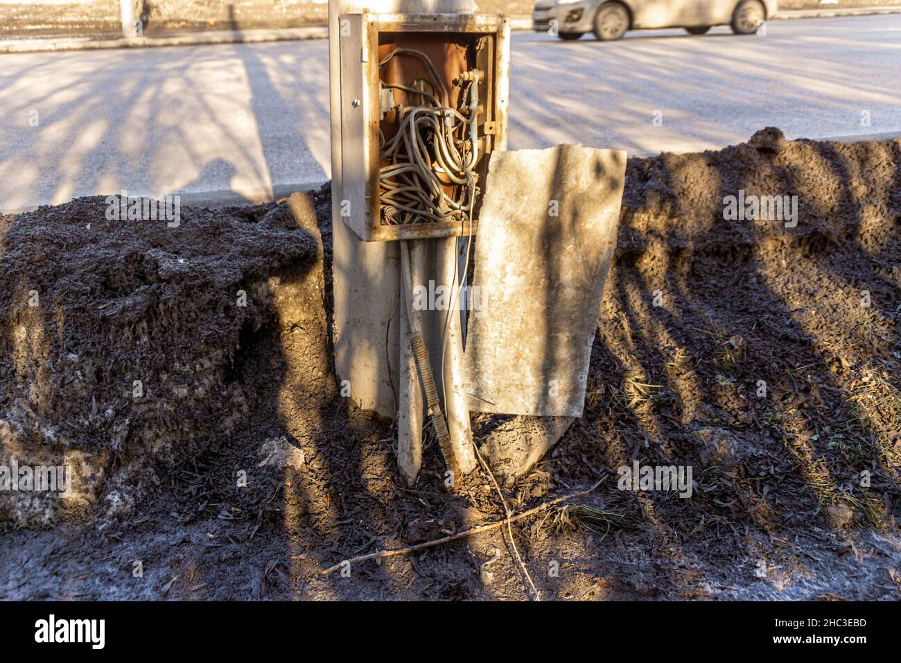 scatola di ferro coperta con fili sul palo dell'illuminazione stradale, cavo di collegamento non autorizzato che esce dalla scatola, messa a fuoco selettiva Foto Stock