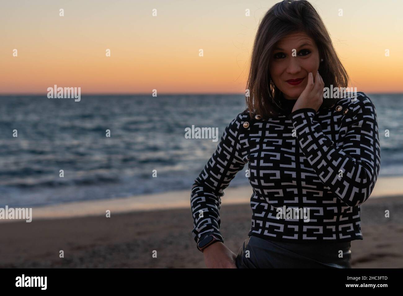 Una giovane donna dai capelli corti che si posa di fronte al mare Foto Stock