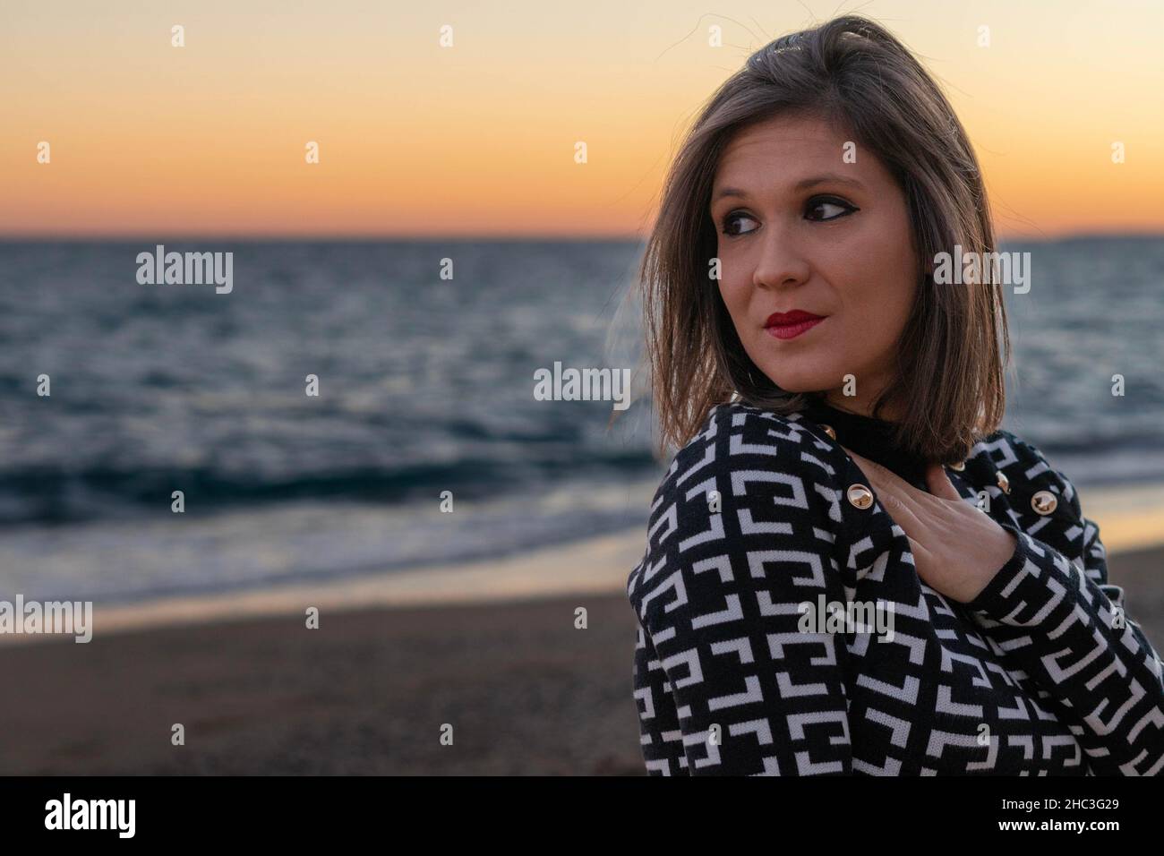 Una giovane donna dai capelli corti che si posa di fronte al mare Foto Stock
