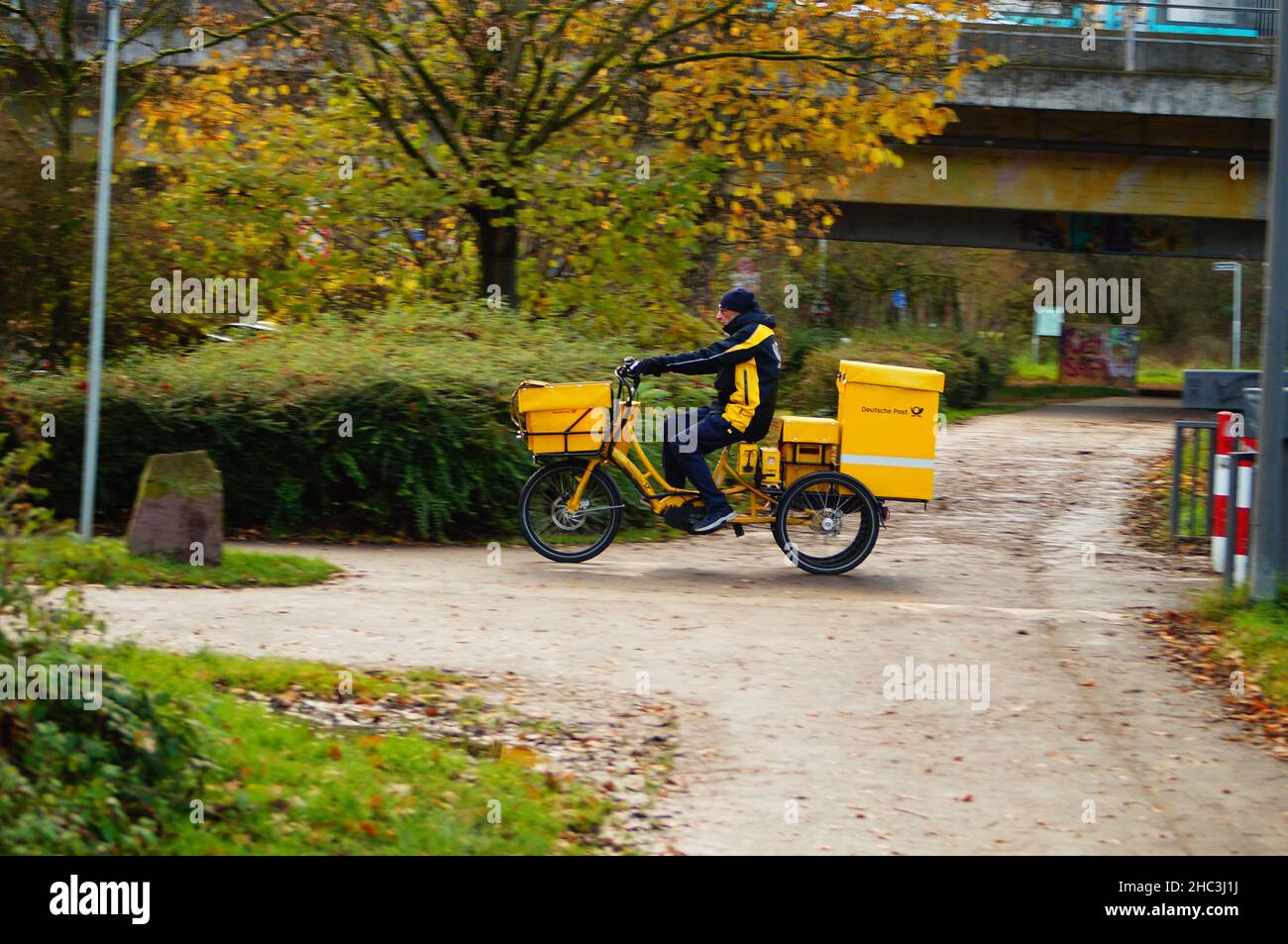 Un postino consegna il suo trasporto. Foto Stock
