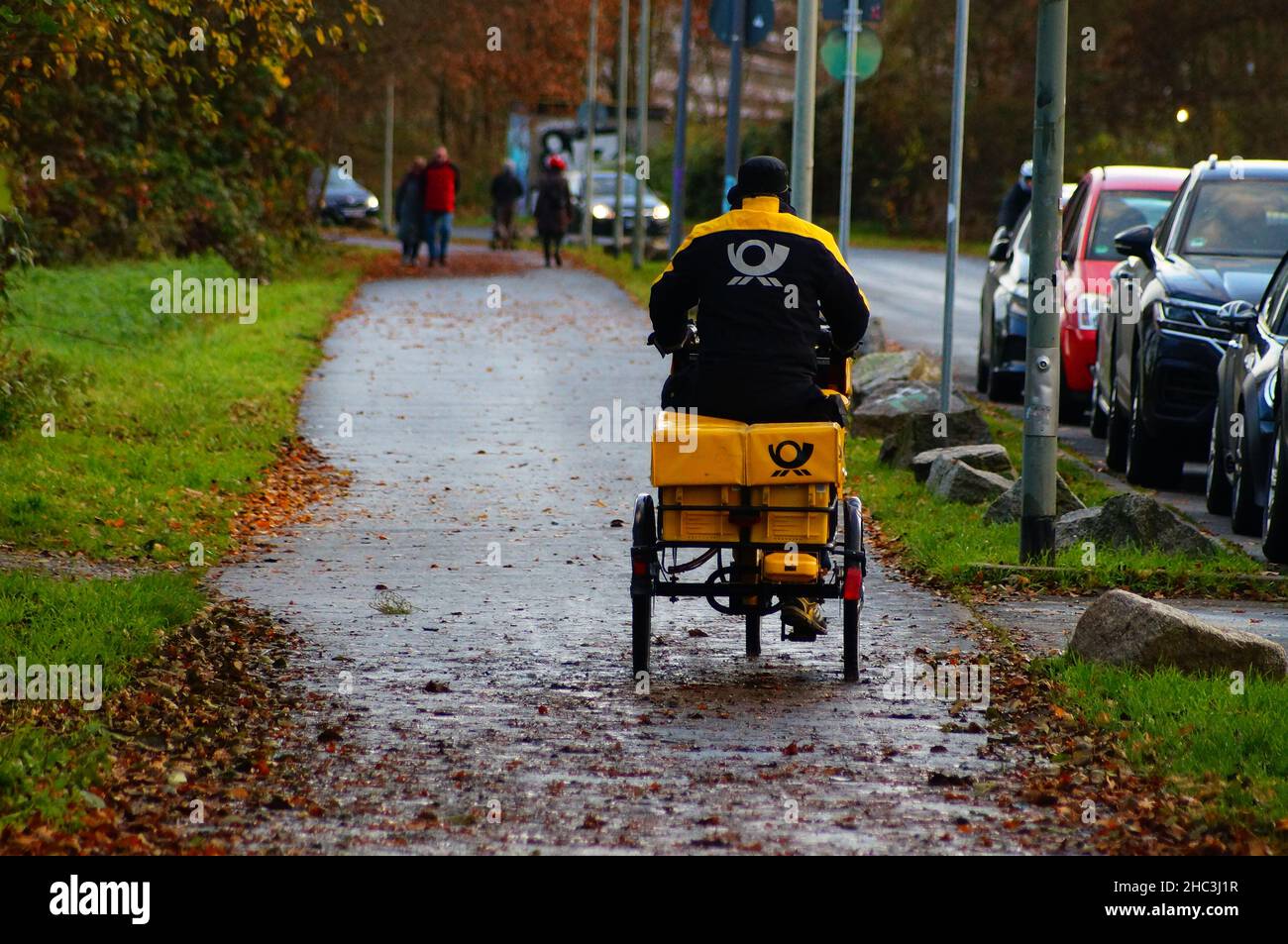 Un postino consegna il suo trasporto. Foto Stock