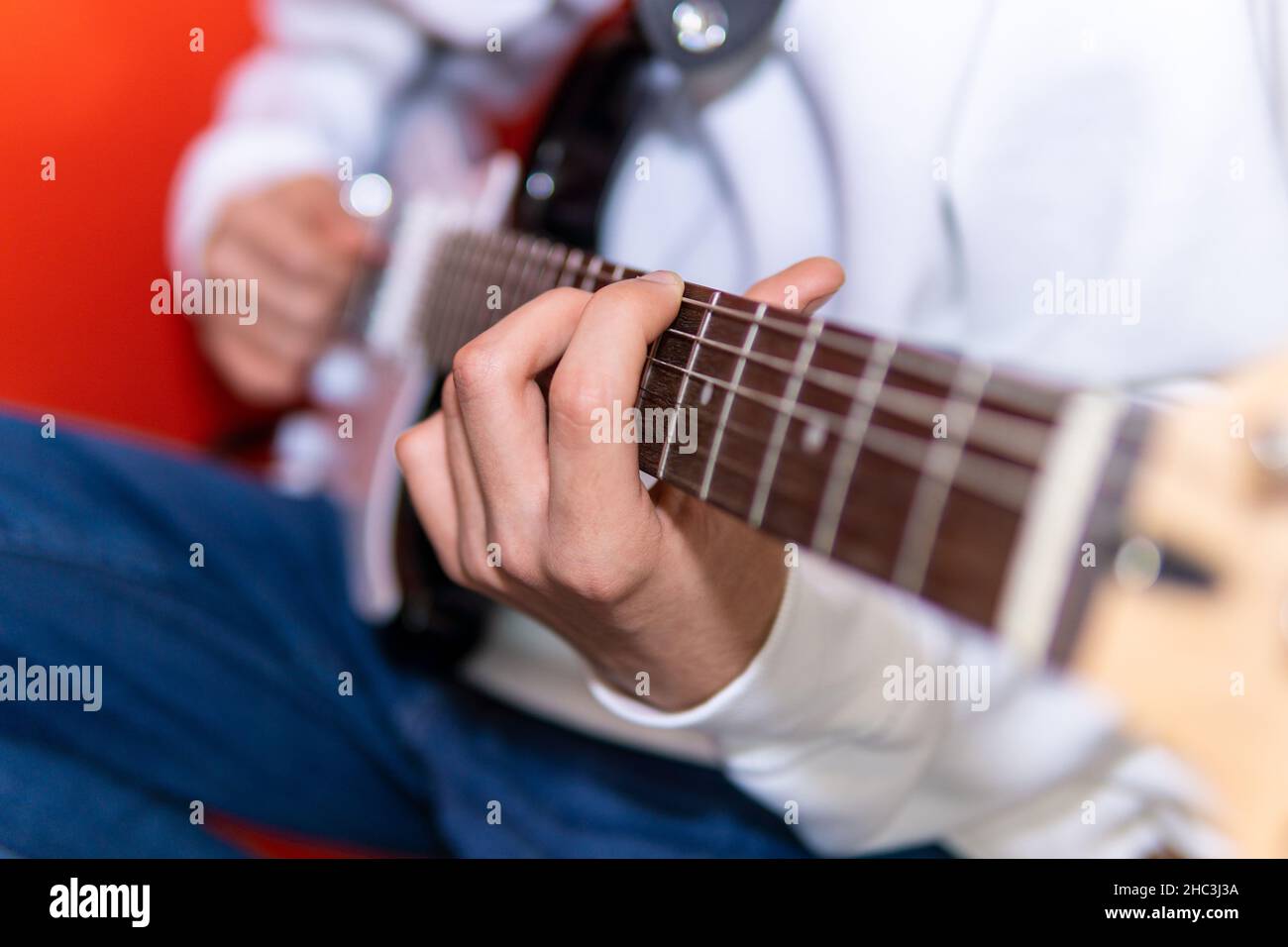 Giovane uomo irriconoscibile che suona la chitarra elettrica. Musica, educazione degli strumenti, intrattenimento, rock star, concerto musicale e concetto di apprendimento Foto Stock