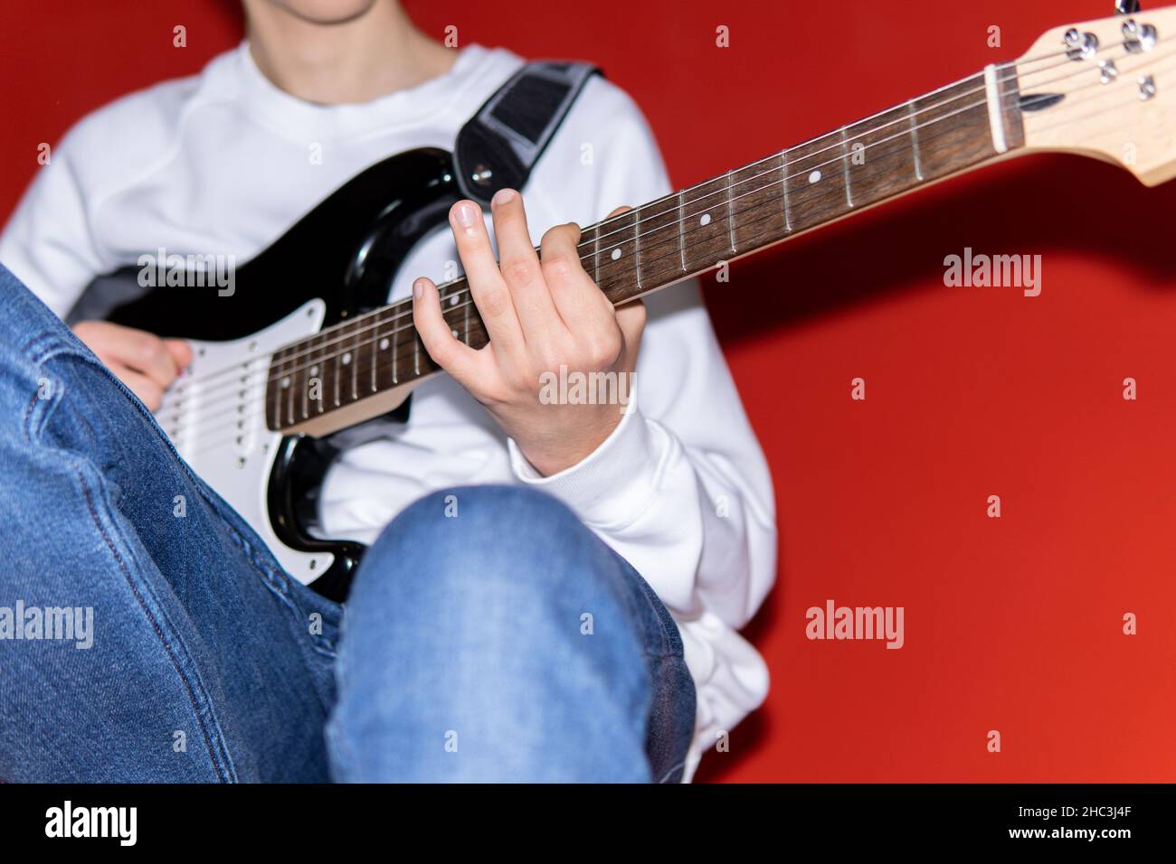 Giovane che suona la chitarra elettrica. Musica, educazione degli strumenti, intrattenimento, rock star, concerto musicale e concetto di apprendimento Foto Stock
