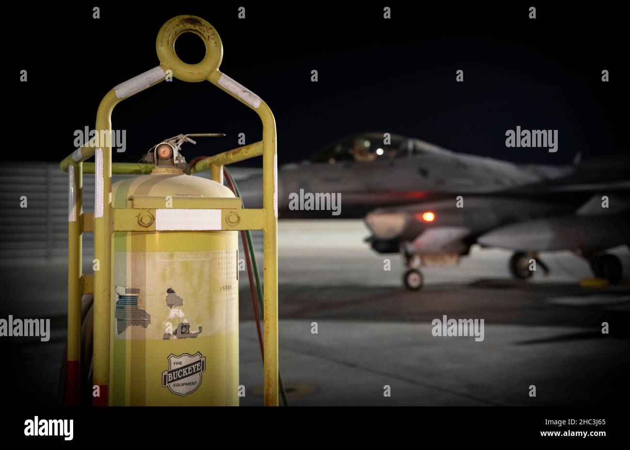 Un US Air Force F-16 Fighting Falcon è parcheggiato vicino ad un estintore flightline durante l'operazione Agile Spartan alla base aerea al Udeid, Qatar, 20 dicembre 2021. Lo Squadron per la manutenzione preventiva del 379th ha facilitato il rifornimento di hot-pit che consente agli aeromobili di atterrare, rifornirsi di carburante, sottoporsi a un'ispezione rapida e decollarsi il più rapidamente possibile con l'intento di aumentare la capacità di deterrenza strategica e la resilienza del pilota. (STATI UNITI Air Force foto di Senior Airman Jacob Dastas) Foto Stock