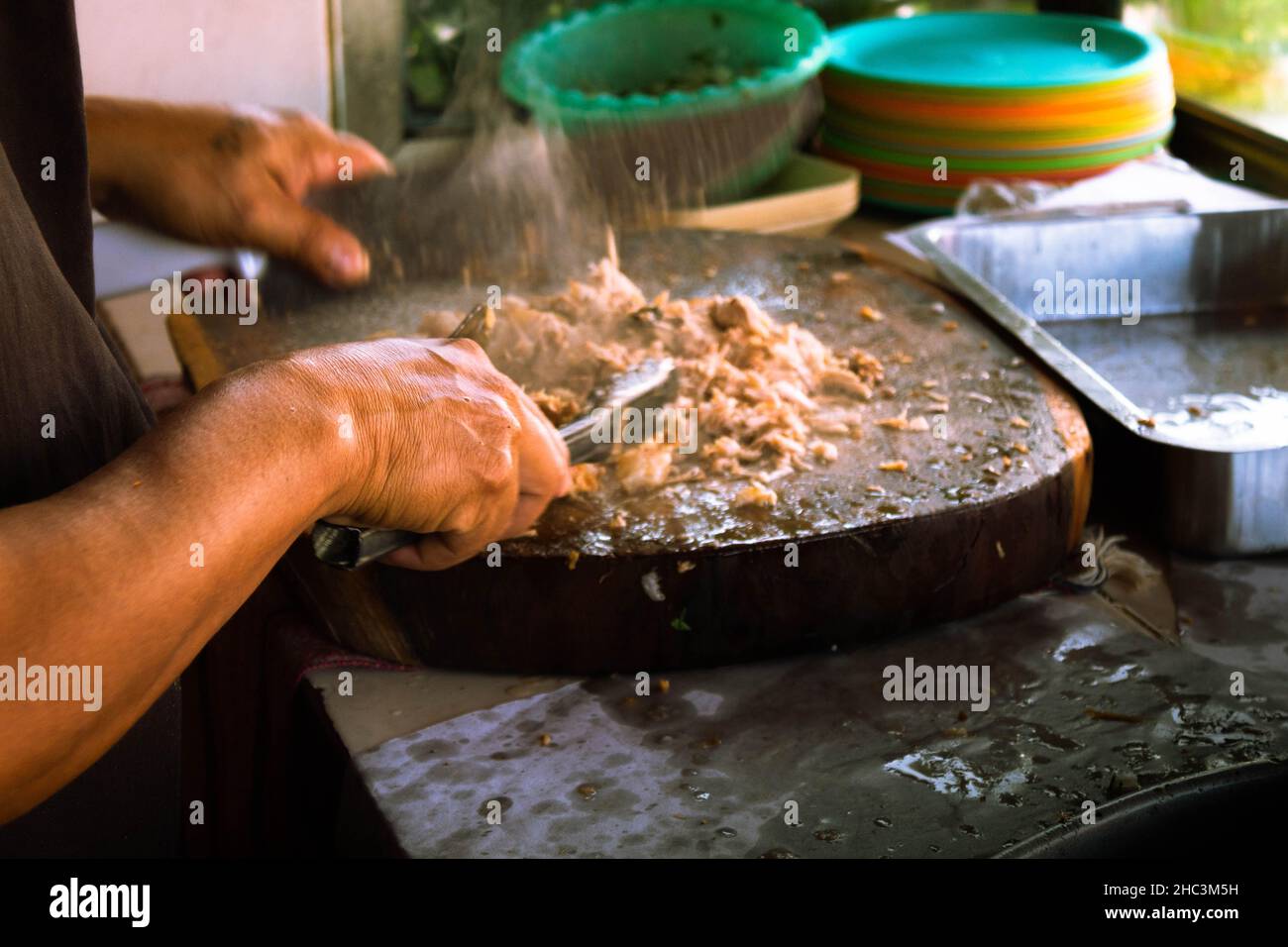 Primo piano dalle mani di un uomo messicano che macina la carne per i tacos tradizionali. Foto di alta qualità Foto Stock