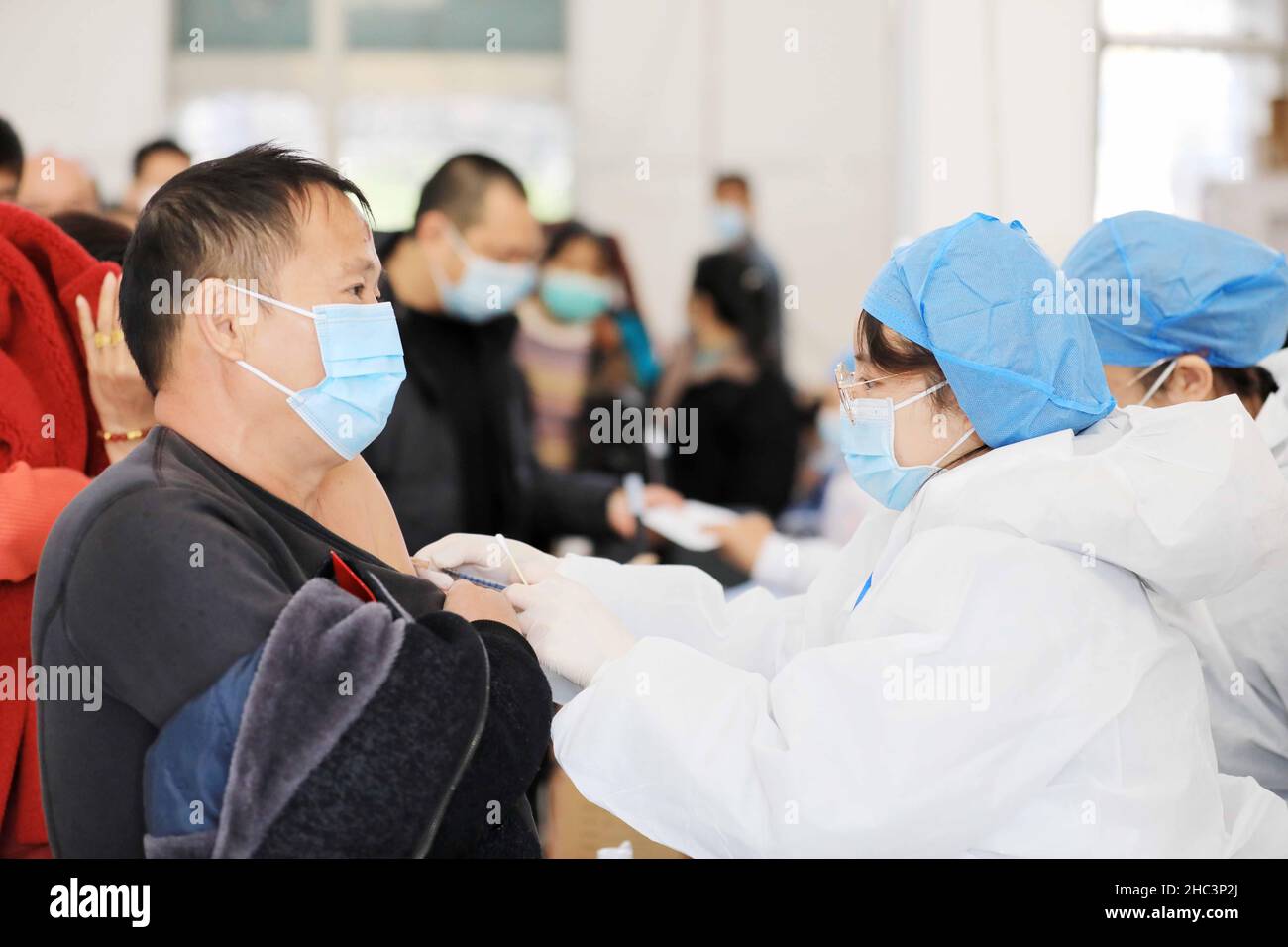 LIUZHOU, CINA - 12 DICEMBRE 2021 - gli operatori sanitari somministrano "ago di richiamo" in un sito di vaccinazione centralizzato per il vaccino COVID-19 a Liuzhou, GU Foto Stock