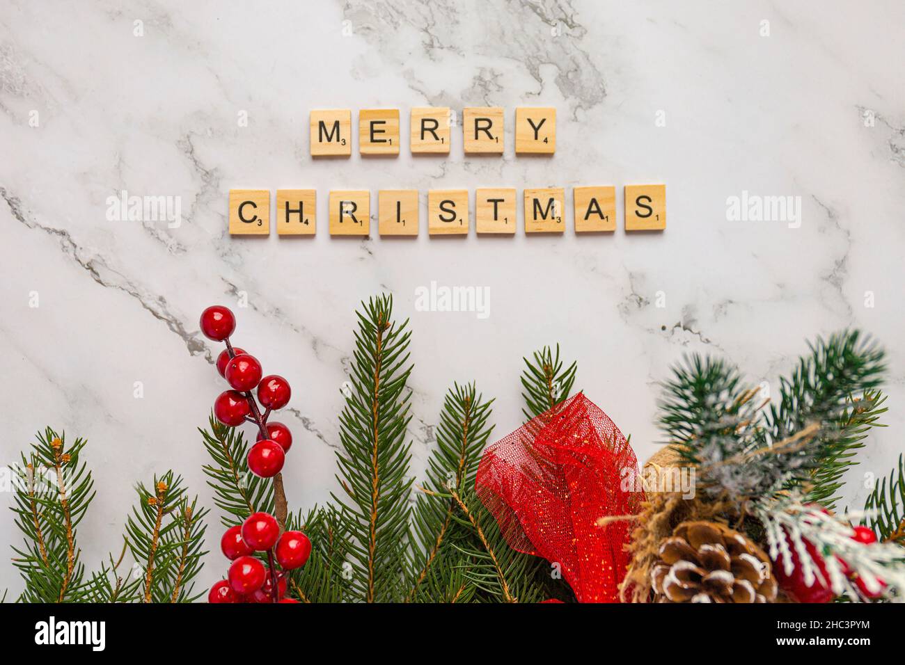 Piastrelle in legno con lettere che formano le parole buon Natale con decorazione di natale, vista dall'alto Foto Stock