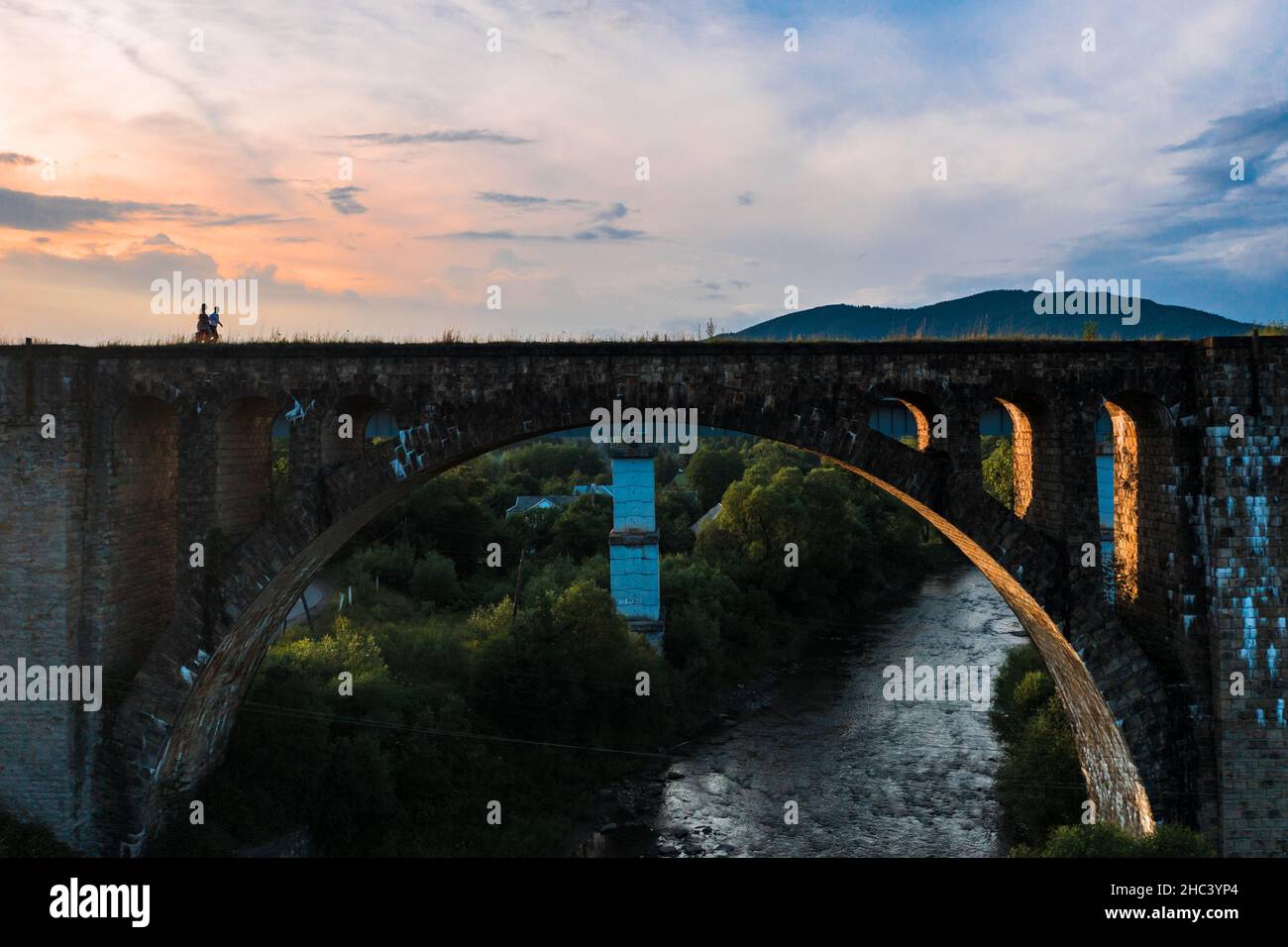 Vorokhta, Ucraina 28 luglio 2021: Un ragazzo e una ragazza camminano sul vecchio ponte, un viadotto in Ucraina, una passeggiata di spose. Foto Stock