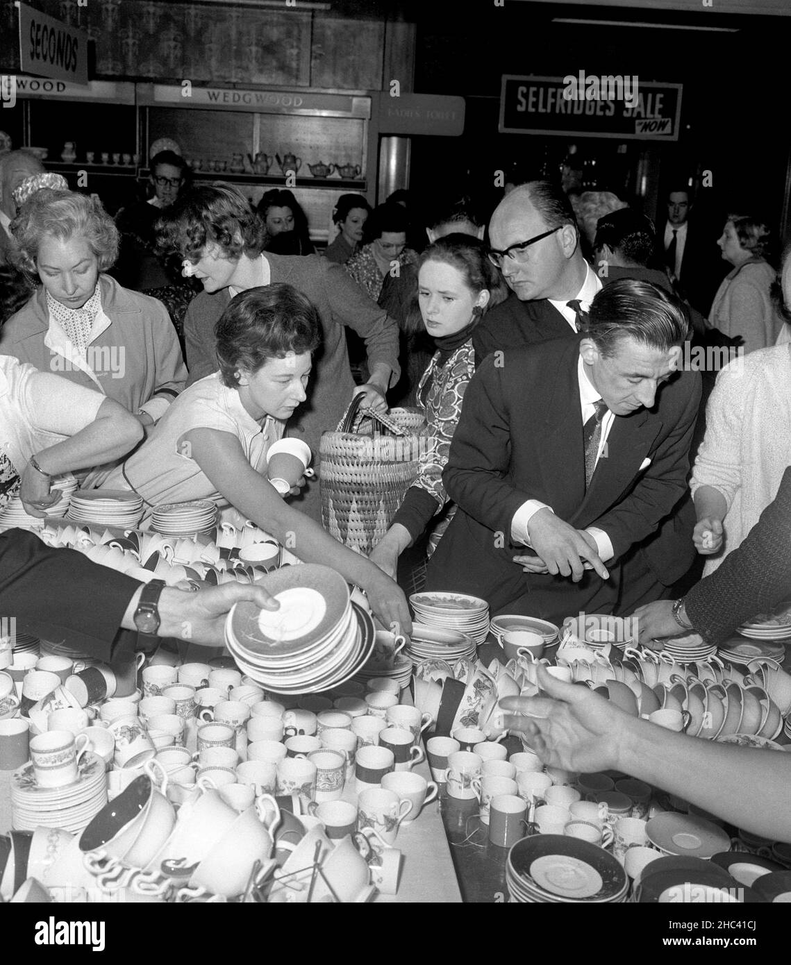 Foto di archivio datata 25/6/1964 di acquirenti nel reparto cinese del negozio Selfridges a Oxford Street, Londra, il primo giorno della vendita di giugno del negozio. La famiglia Weston ha venduto il gruppo di lusso Selfridges, fondato nel 1908 da Harry Gordon Selfridge, al rivenditore Signa Holding e alla società immobiliare Central Group. Data di emissione: Venerdì 24 dicembre 2021. Foto Stock