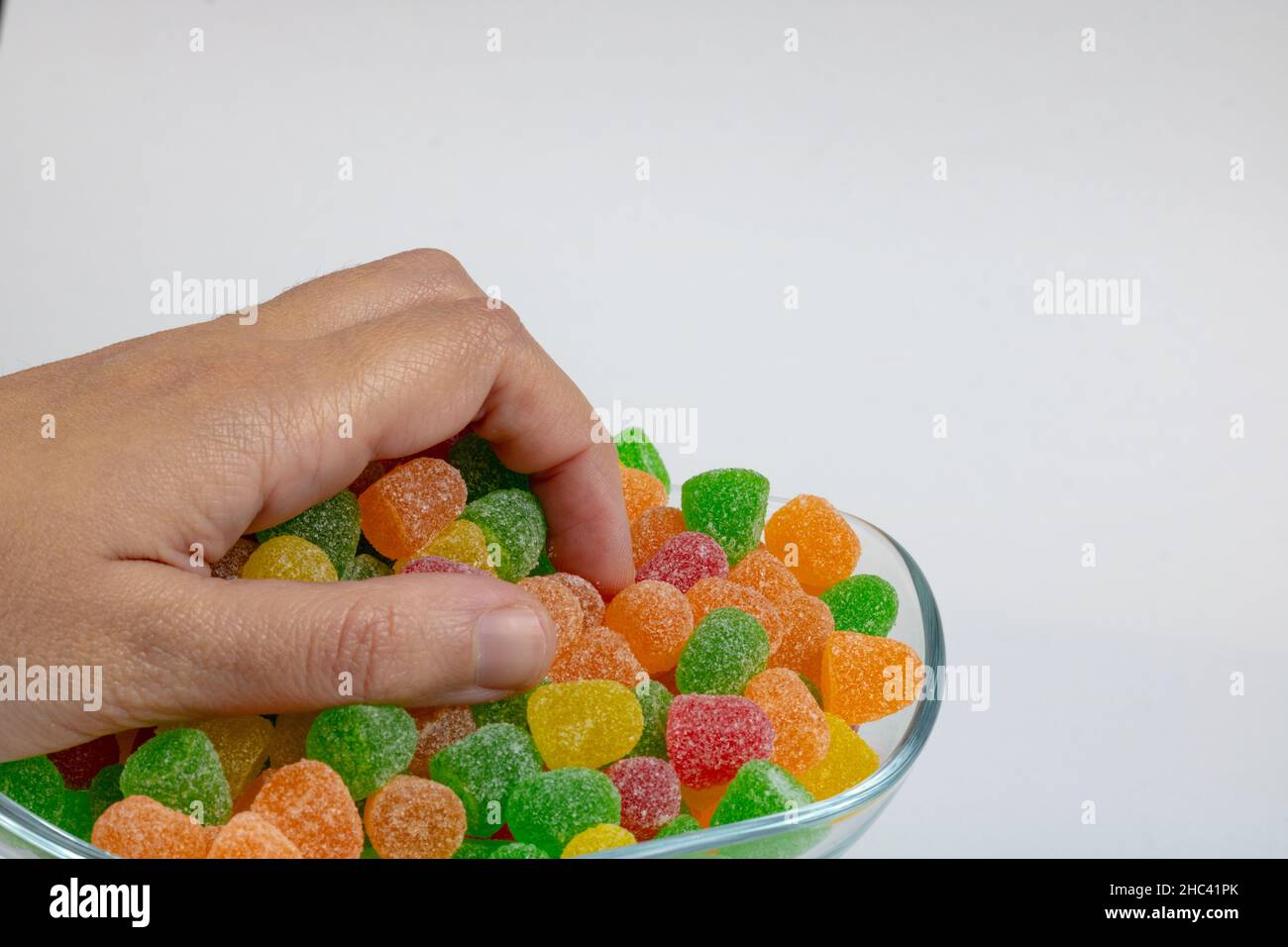 Caramelle gommosi. Uomo che prende una manciata di caramelle gelatinose  isolate su sfondo bianco Foto stock - Alamy