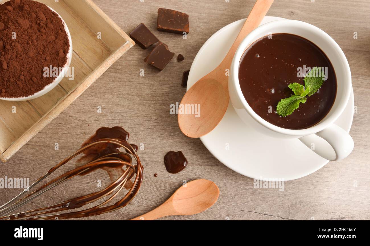 Preparazione della ricetta al cioccolato caldo con ingredienti sul tavolo da cucina. Vista rialzata. Foto Stock