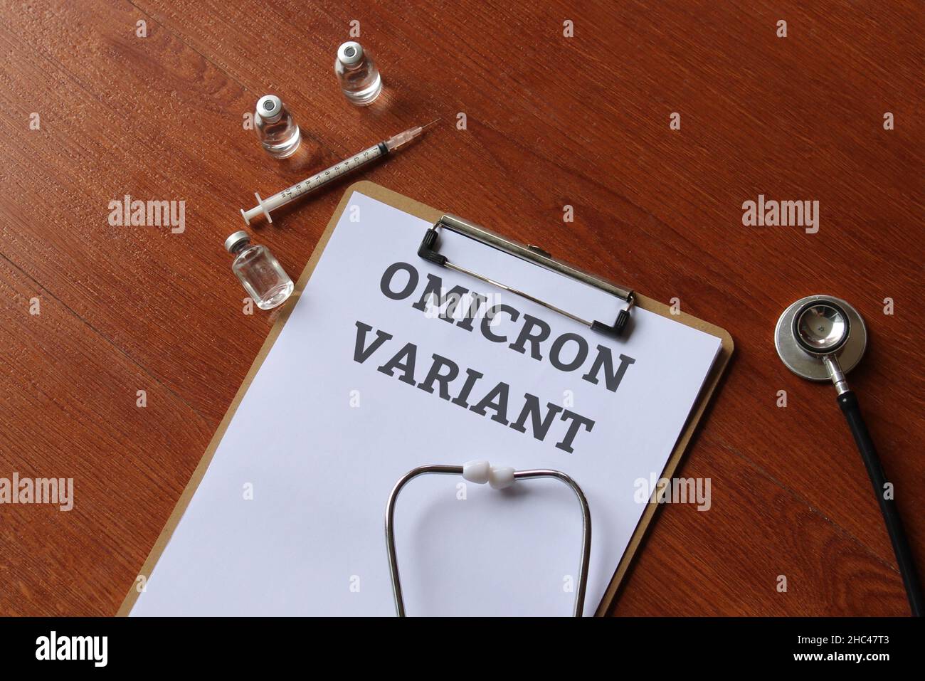 Vista dall'alto dello stetoscopio, flaconcino di vetro, siringa e appunti di carta con testo VARIANTE OMICRON Foto Stock