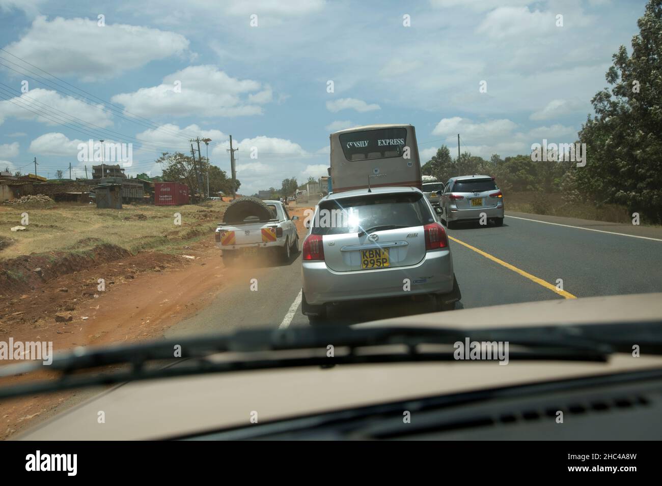 Auto sorpasso altro traffico sul lato sinistro e su linea continua gialla su Mombasa Road Kenya Foto Stock