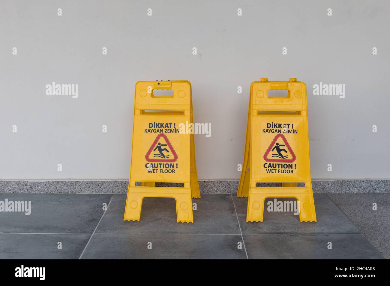 Attenzione cartello pavimento bagnato in lingua inglese e turca Foto Stock