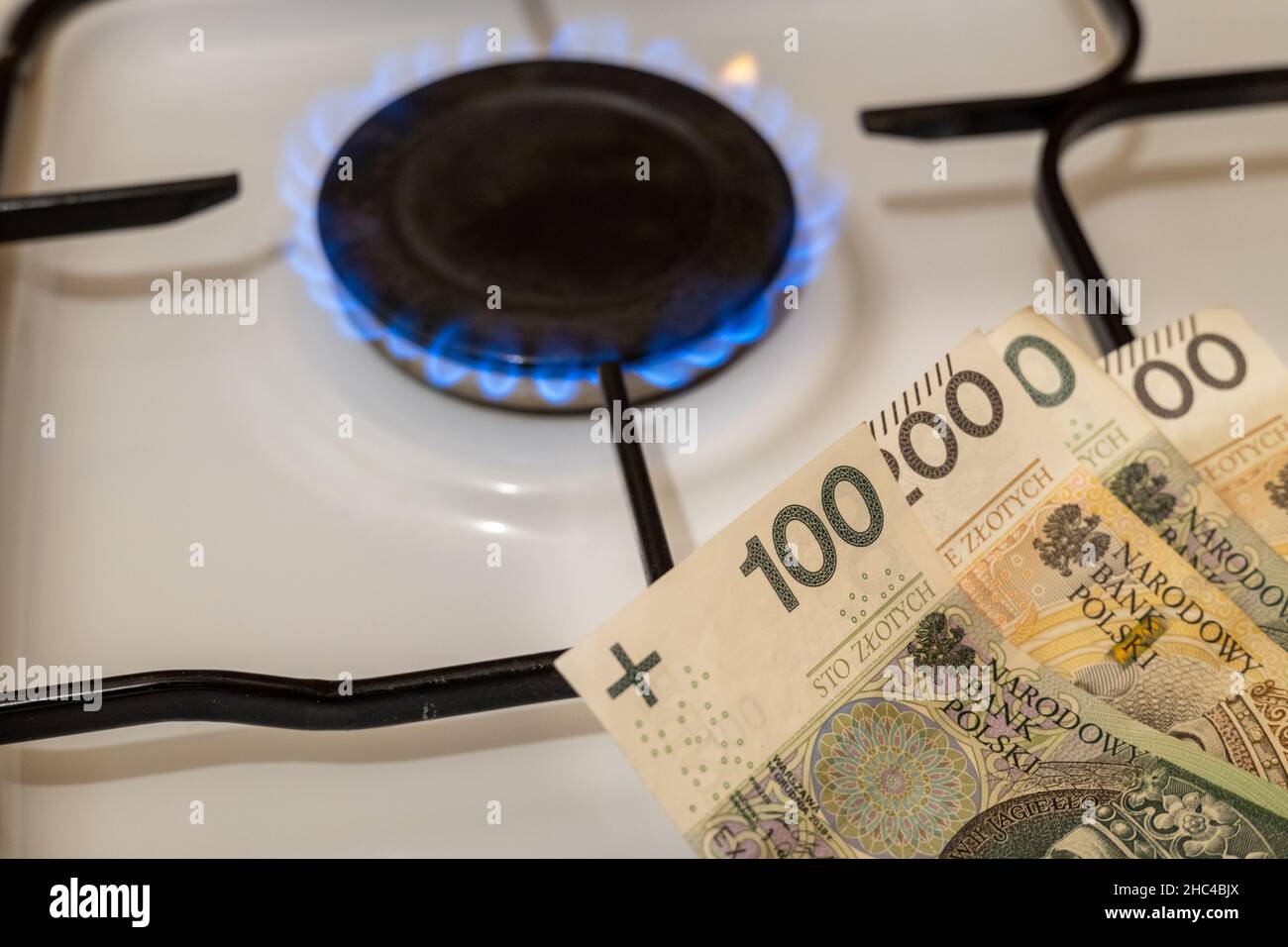 Stufa a gas con cento e duecento banconote polacche zlotys, il concetto di grande gas aumenta nel 2022 Foto Stock