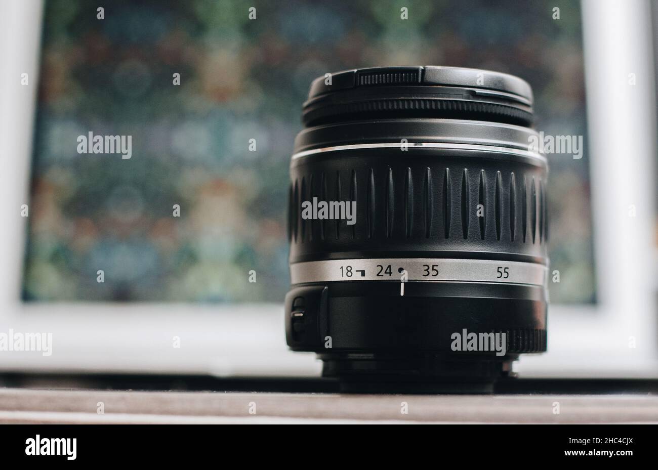 Primo piano di un obiettivo fotografico con sfondo bokeh sul tavolo. Foto Stock