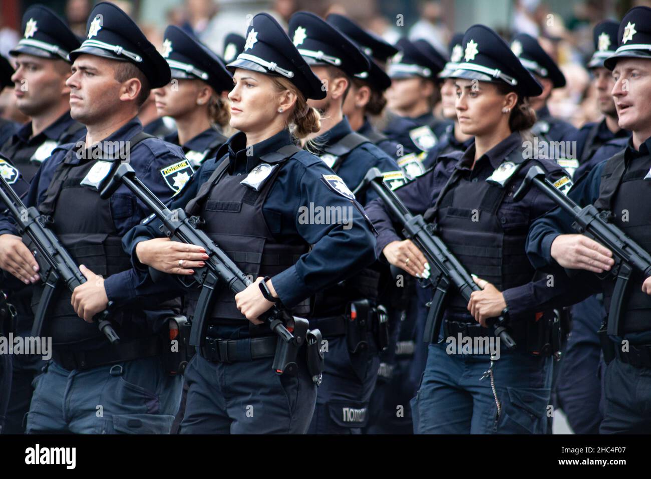 Ucraina, Kiev - 18 agosto 2021: Fuoco selettivo. Poliziotto ucraino con una mitragliatrice. Un uomo e una donna in uniforme. La polizia sta marciando nella sfilata. Fucile automatico. Esercito Foto Stock