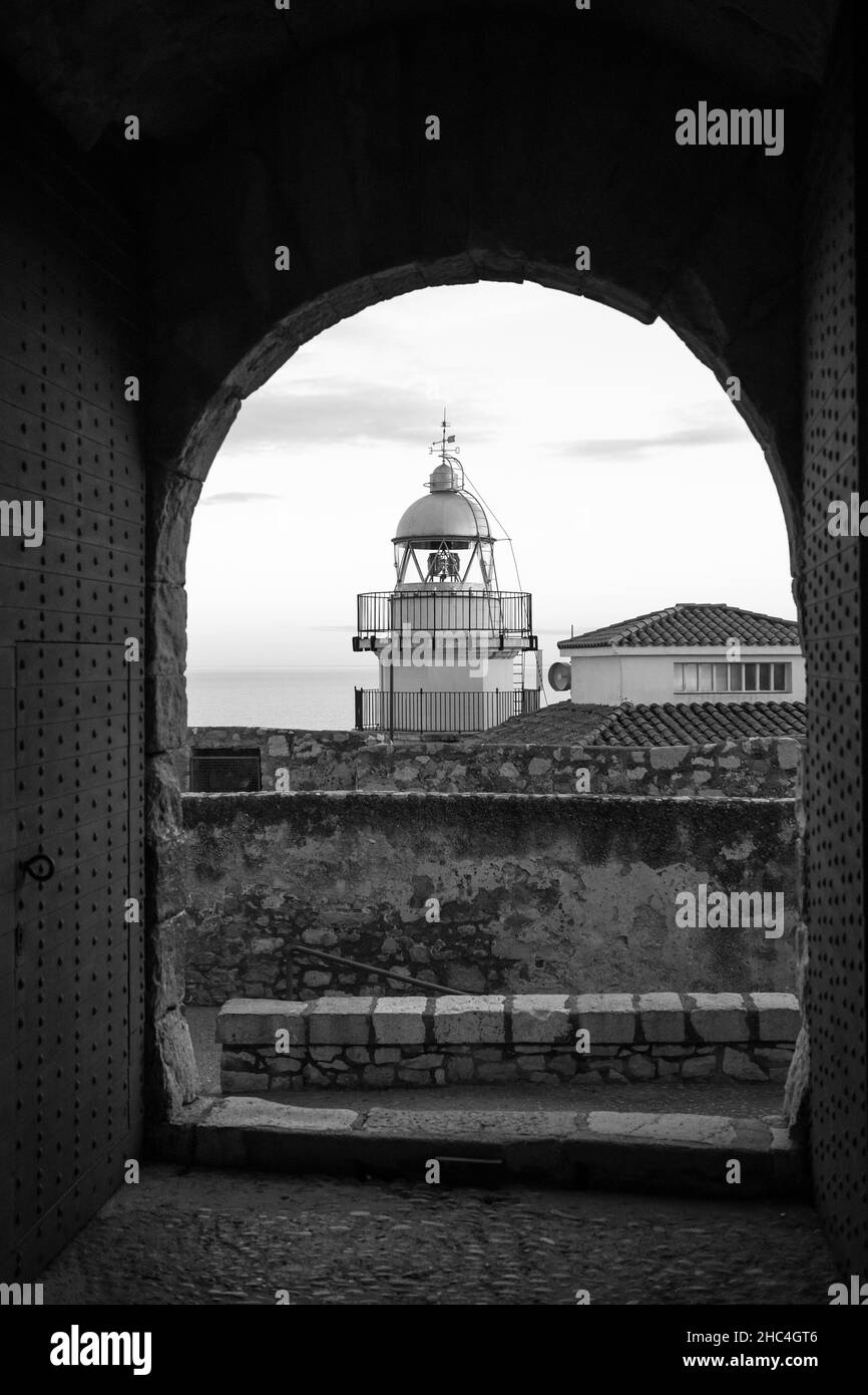 Faro di Peniscola visto dal balcone ad arco e Castello nella Città Vecchia di Peniscola, Castellon, Spagna. Settembre 2021. Scatto verticale. Foto Stock
