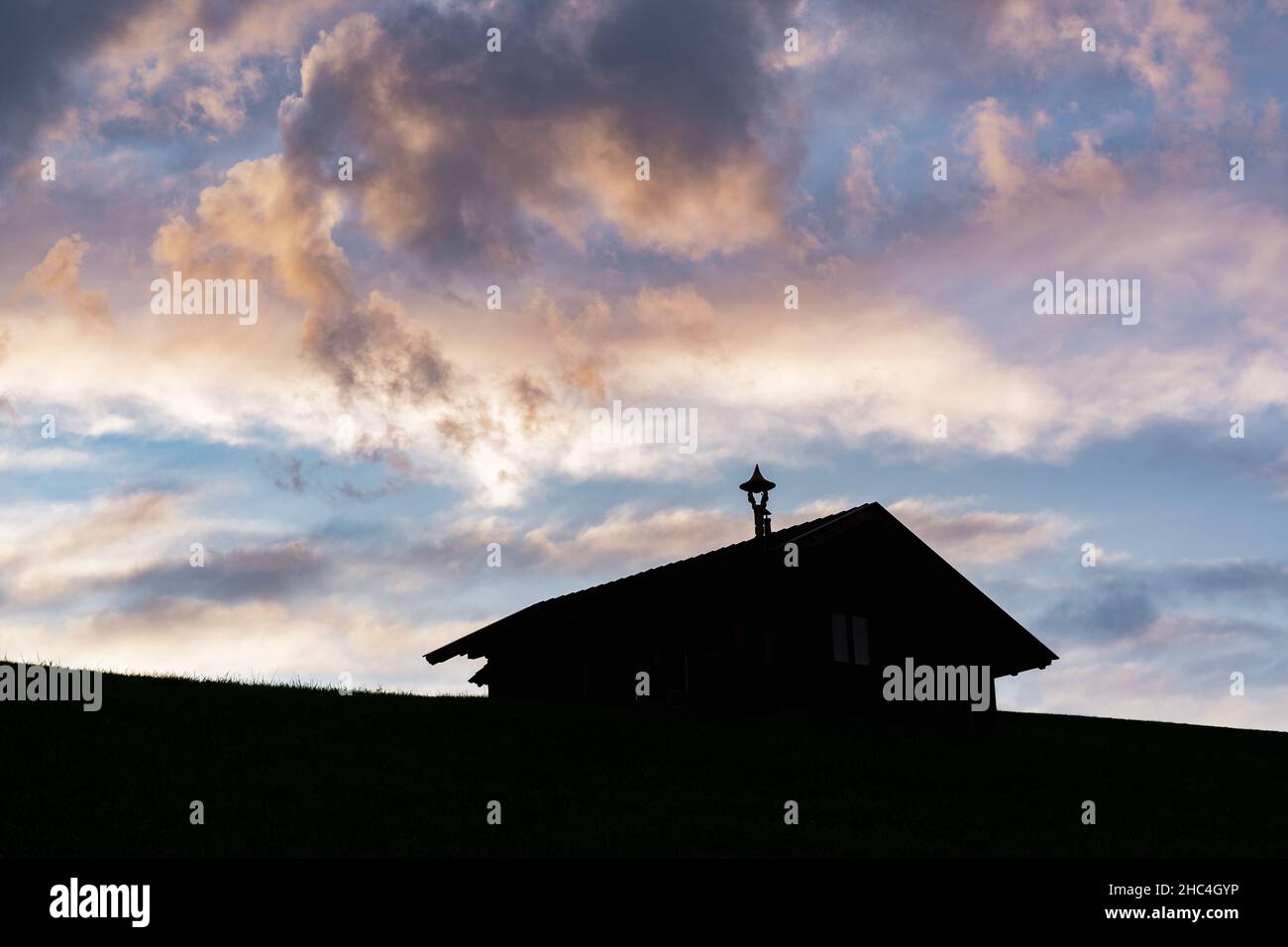 tramonto colorato su una vecchia casa di legno in montagna Foto Stock