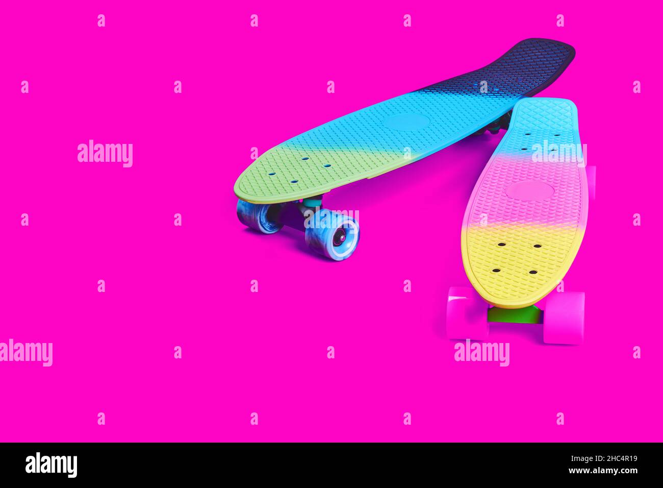 Due skateboard in plastica Rainbow Penny su sfondo cremisi Foto Stock