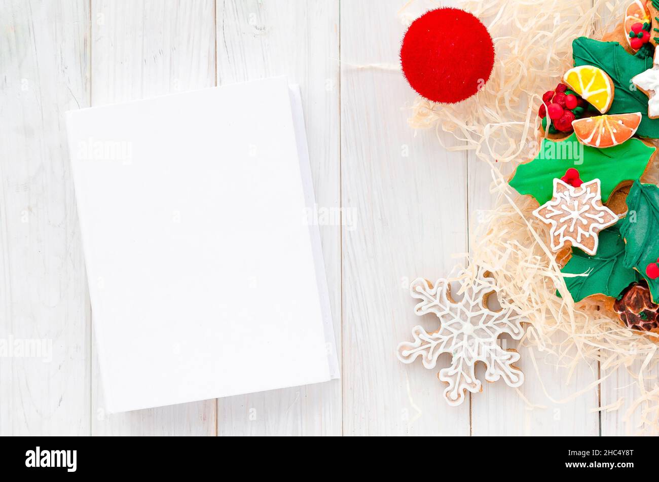 Concetto di Natale. Pan di zenzero nella forma di una corona di Natale si trova su uno sfondo bianco di legno Foto Stock