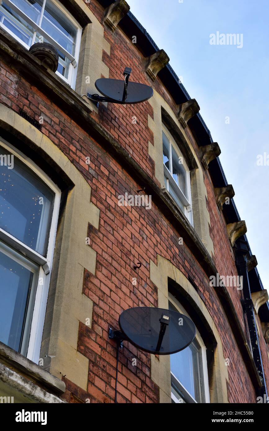 TV satellitare che riceve piatti sul lato della casa di mattoni, Stroud, Regno Unito Foto Stock