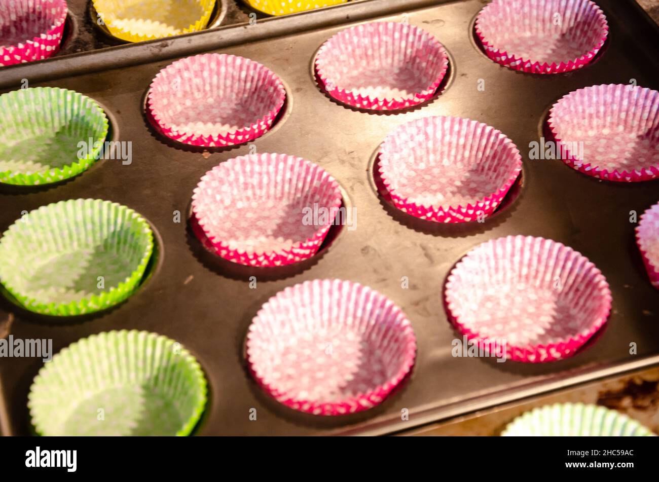 Svuotare i contenitori per cupcake in teglie leggere per essere riempiti. Foto Stock