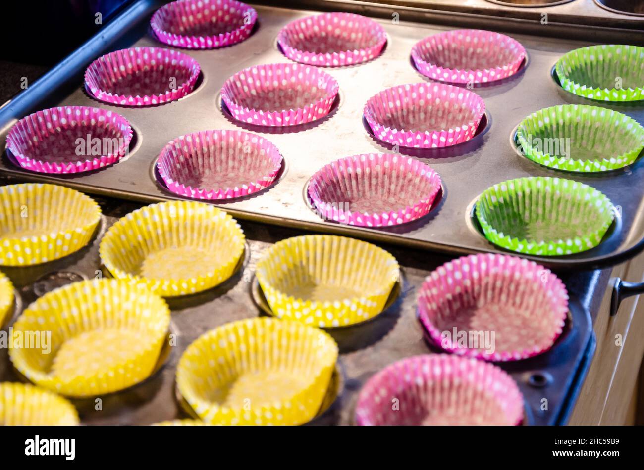 Svuotare i contenitori per cupcake in teglie leggere per essere riempiti. Foto Stock