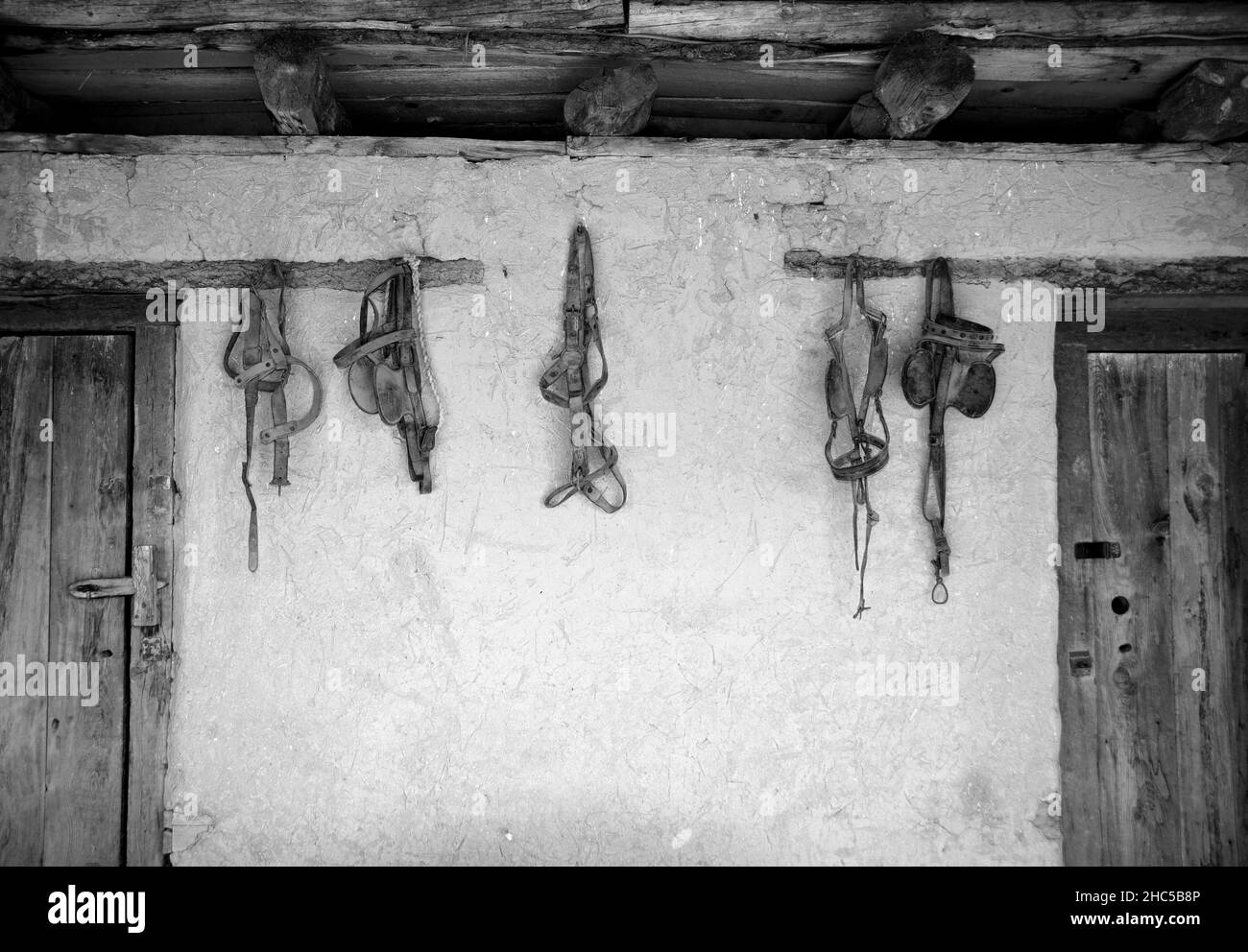 Antichi mulinelli a cavallo appendono su un muro di stanza del sacco a El Rancho de las Golondrinas complesso di storia vivente vicino a Santa Fe, New Mexico. Foto Stock